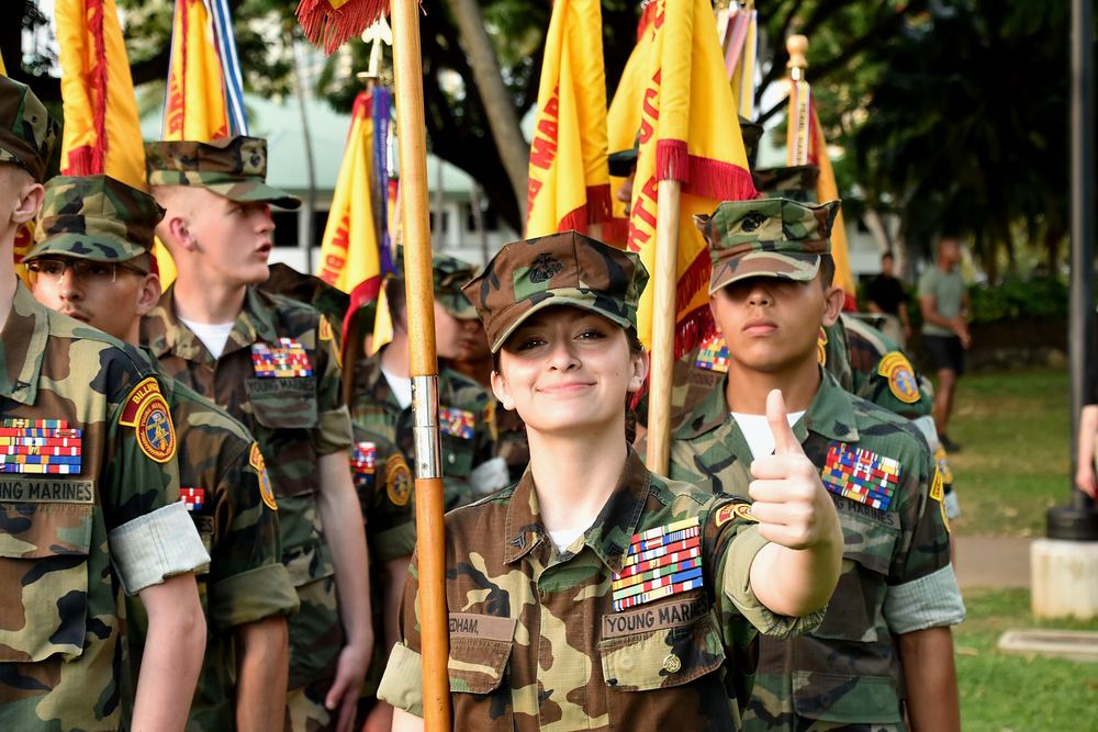 A Young Marine in the color guard giving a thumbs up before stepping off